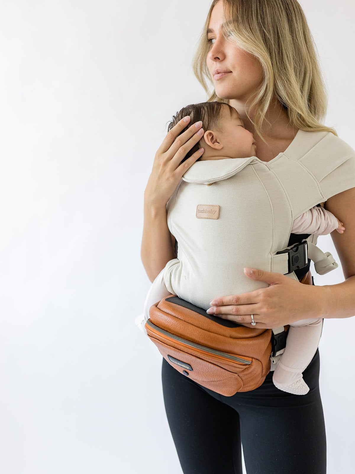 Tushbaby Portabebés Manos Libres 2 en 1 con Soporte Lumbar, Asiento Ergonómico y Almacenamiento Integrado, Para Niños de 5.4 a 20 kg En Piel Vegana y Color Crema