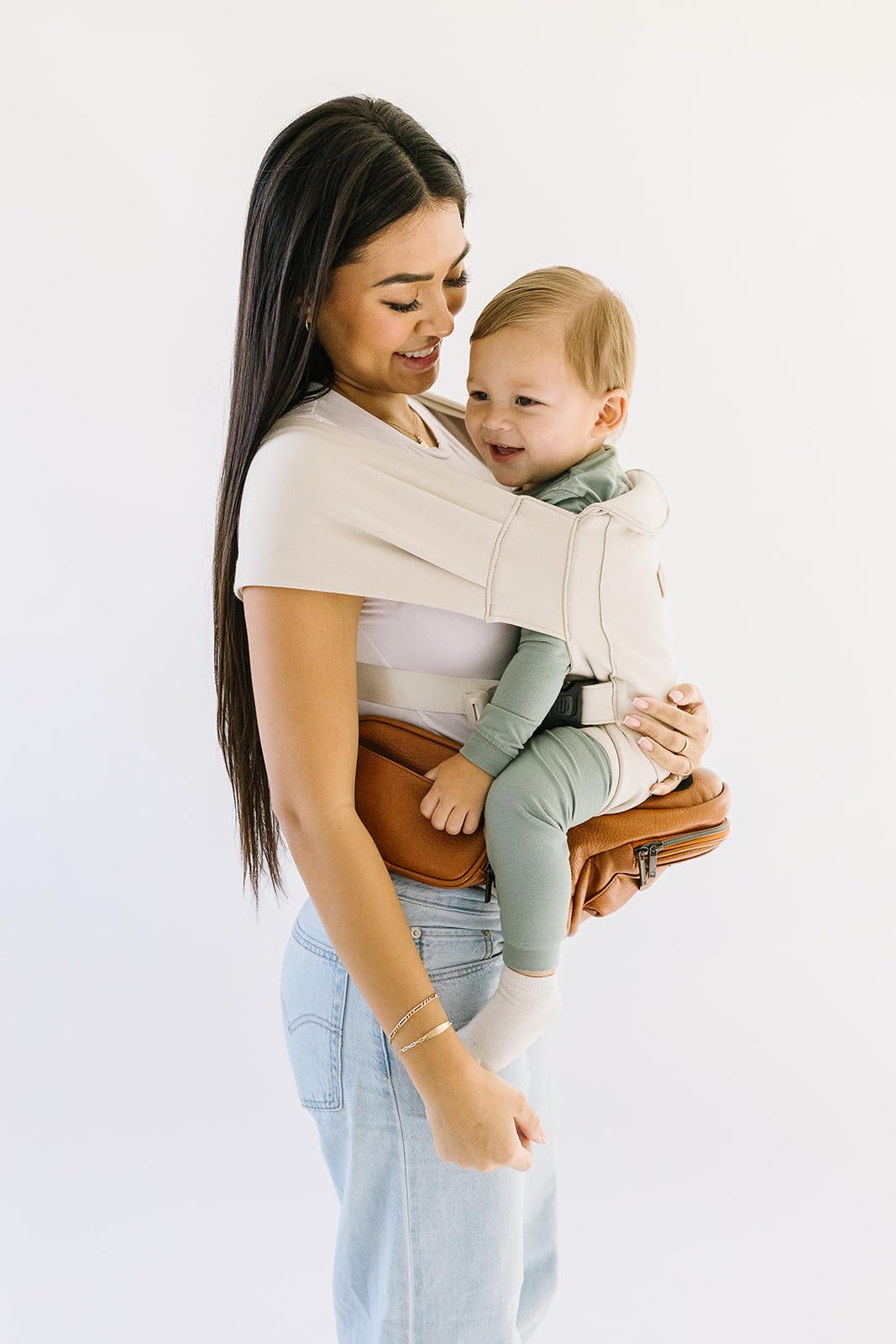 Tushbaby Portabebés Manos Libres 2 en 1 con Soporte Lumbar, Asiento Ergonómico y Almacenamiento Integrado, Para Niños de 5.4 a 20 kg En Piel Vegana y Color Crema